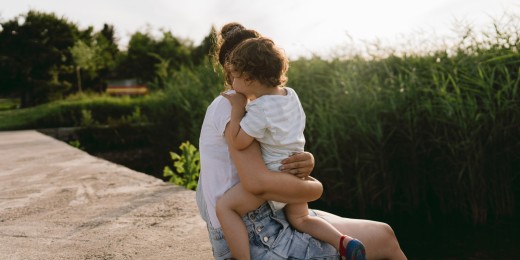 Une maman avec son enfant au bord d'un lac finlandais