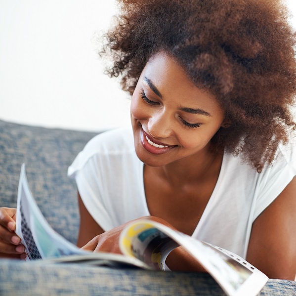 Une jeune femme lit son magazine