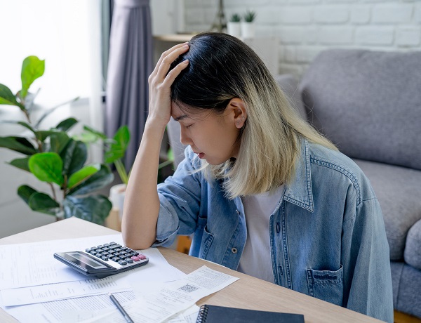 Maman inquiète devant ses factures, soulignant l'importance du Secal pour garantir des contributions alimentaires accessibles à tous